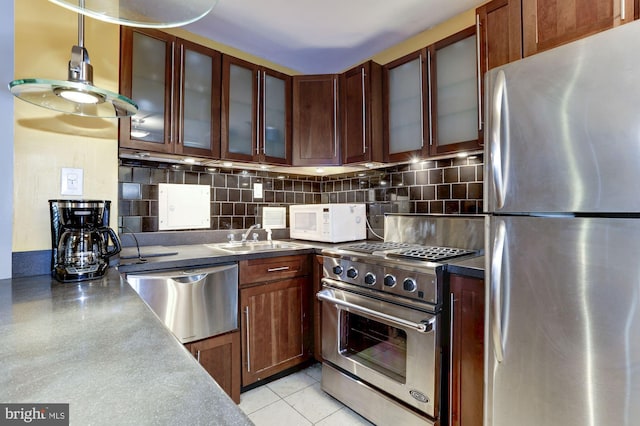 kitchen featuring pendant lighting, sink, light tile patterned floors, backsplash, and stainless steel appliances