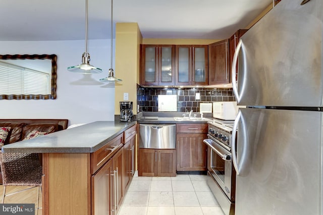 kitchen featuring decorative backsplash, stainless steel appliances, kitchen peninsula, and hanging light fixtures