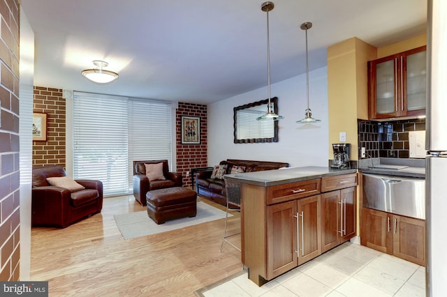 kitchen featuring pendant lighting, a kitchen breakfast bar, light hardwood / wood-style floors, and kitchen peninsula