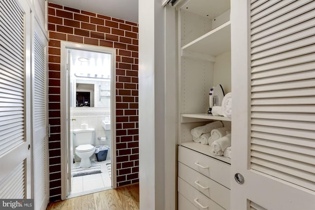 bathroom with tile walls and hardwood / wood-style floors