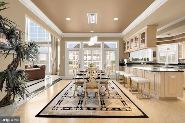 interior space featuring crown molding, pendant lighting, a chandelier, and cream cabinetry