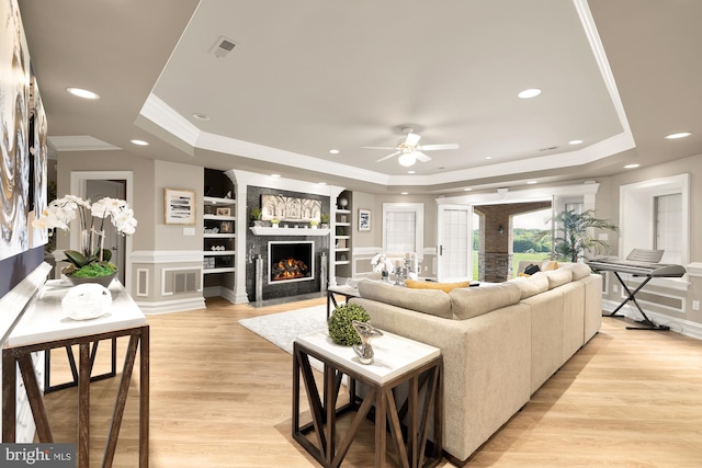 14950 Kelley Farm, Darnestown, MD 20874 - living room featuring a tray ceiling, ornamental molding, built in features, a fireplace with flush hearth, and light wood-style floors