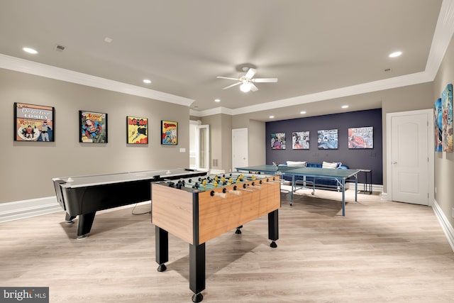 rec room featuring ceiling fan, ornamental molding, and light wood-type flooring