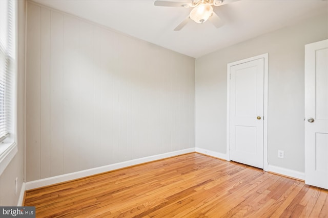 empty room with ceiling fan, plenty of natural light, and light wood-type flooring