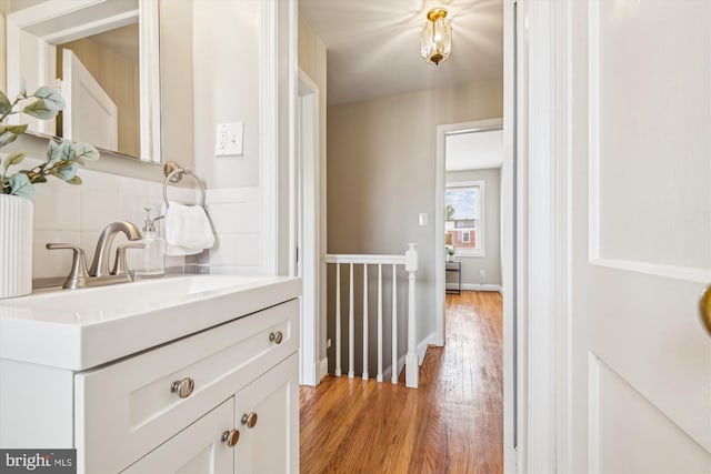 bathroom with wood-type flooring, vanity, and tasteful backsplash