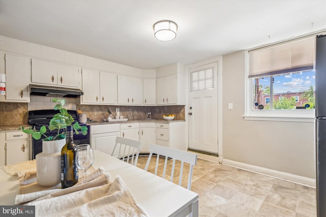 kitchen with white cabinetry, sink, black range with electric cooktop, and tasteful backsplash