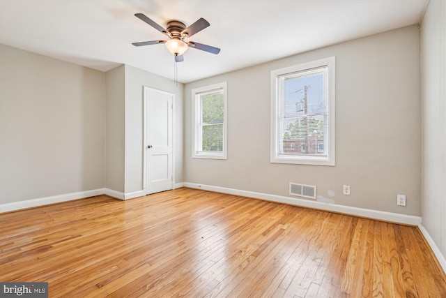 empty room with ceiling fan and light hardwood / wood-style floors