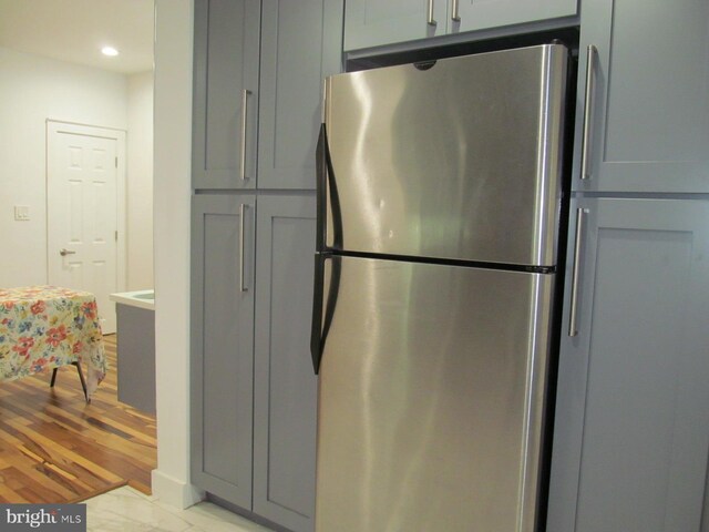 kitchen with tasteful backsplash, appliances with stainless steel finishes, gray cabinets, and wood-type flooring