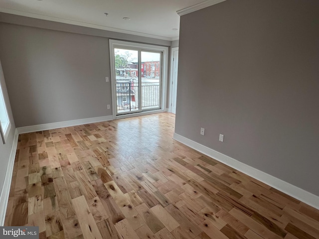 empty room with crown molding and light hardwood / wood-style flooring