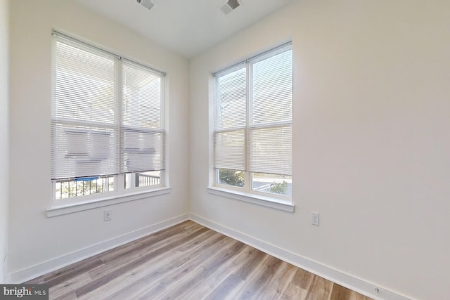 spare room featuring plenty of natural light and light hardwood / wood-style floors