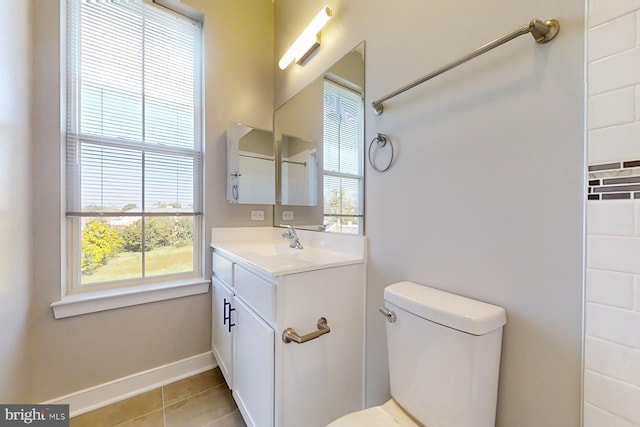 bathroom with toilet, vanity, tile patterned floors, and plenty of natural light