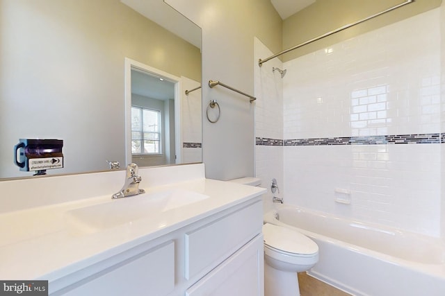 full bathroom with vanity, tiled shower / bath combo, and toilet