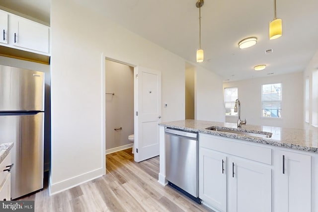 kitchen with sink, light hardwood / wood-style floors, decorative light fixtures, white cabinets, and appliances with stainless steel finishes