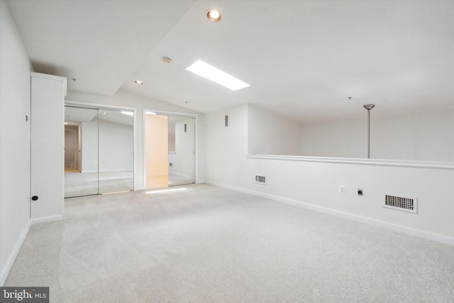 carpeted empty room with lofted ceiling