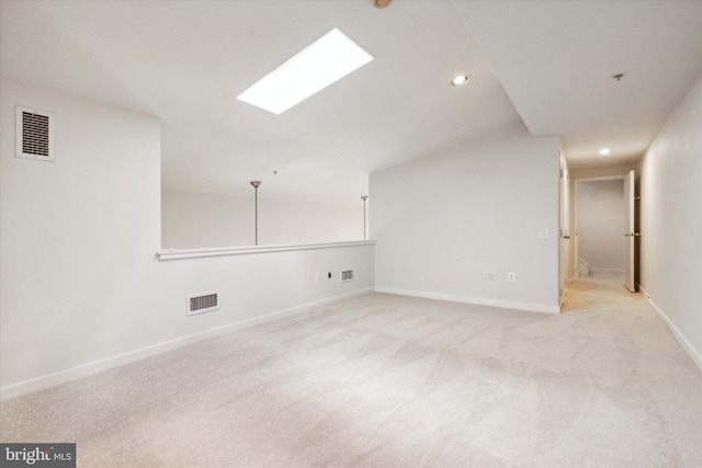 bonus room with light colored carpet and lofted ceiling with skylight