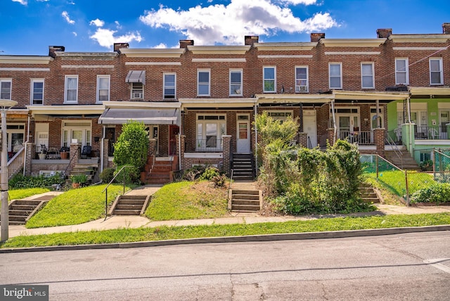 view of property featuring brick siding and stairway