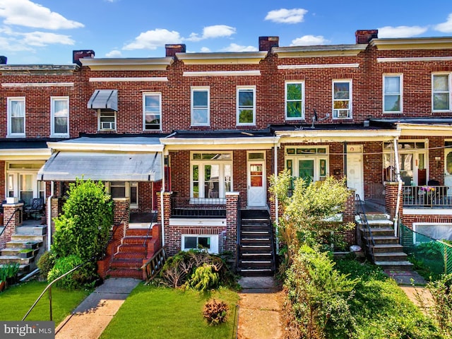 view of property featuring stairway and brick siding