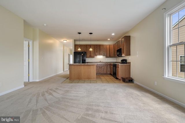 kitchen with a center island, sink, pendant lighting, light colored carpet, and black appliances