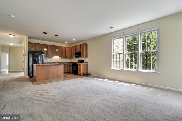 kitchen with light carpet, a center island, decorative light fixtures, and black appliances