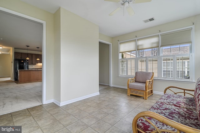 living area with ceiling fan and light tile patterned flooring