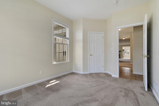 spare room featuring light colored carpet