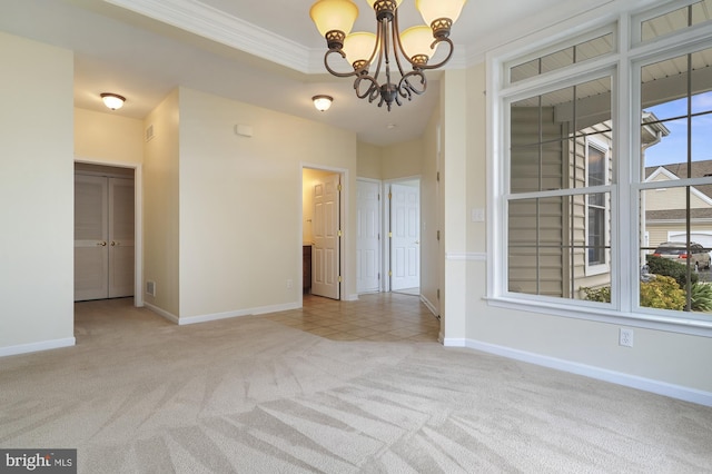 empty room featuring a healthy amount of sunlight, crown molding, light carpet, and a chandelier