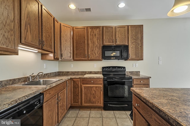 kitchen with light tile patterned floors, sink, and black appliances