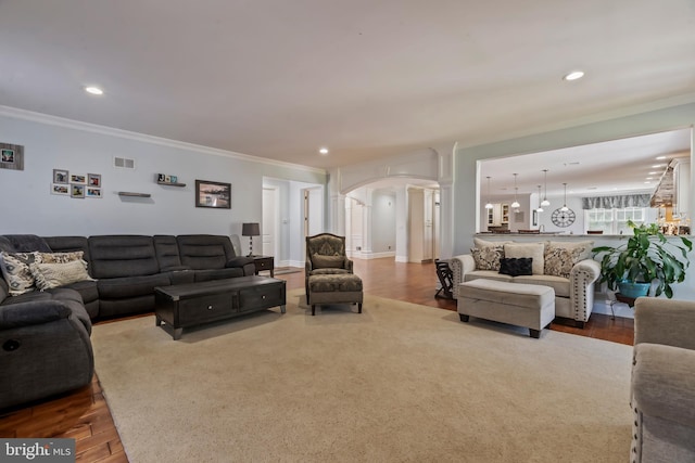 living room with hardwood / wood-style flooring, ornate columns, and crown molding