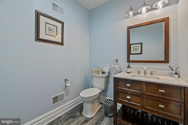 bathroom featuring vanity, wood-type flooring, and toilet