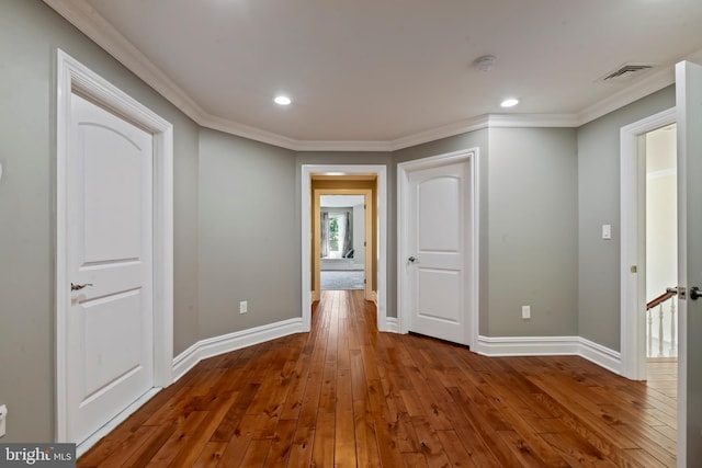 empty room with hardwood / wood-style flooring and crown molding