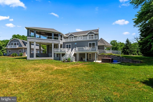 back of property with a yard, a deck, and a sunroom