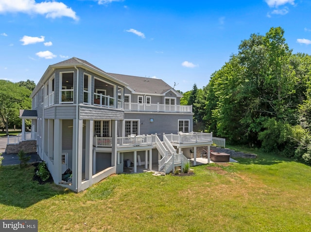 back of property featuring a deck and a lawn