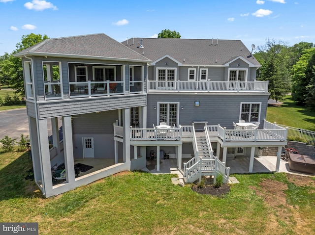 back of property featuring a lawn, a patio area, a deck, and a balcony