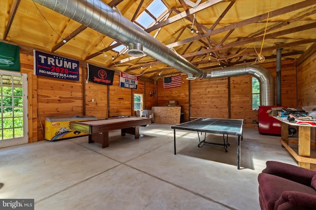 rec room with wood walls, lofted ceiling, and concrete floors