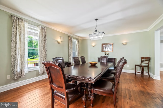 dining space with a chandelier, hardwood / wood-style flooring, and crown molding