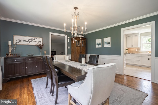 dining space with dark hardwood / wood-style flooring, a notable chandelier, and ornamental molding