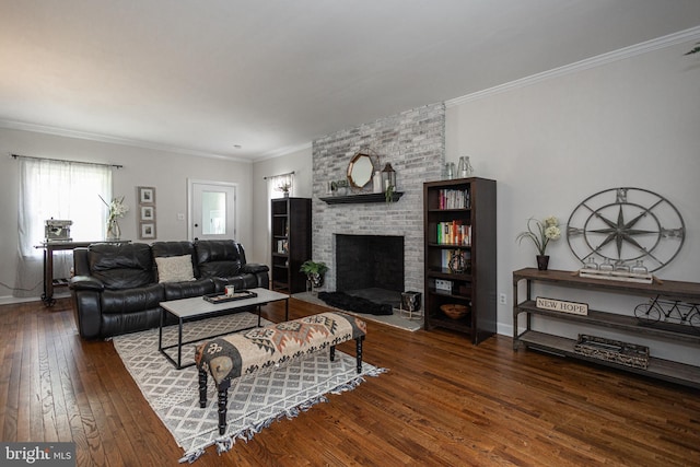 living room with crown molding, dark hardwood / wood-style floors, and a brick fireplace