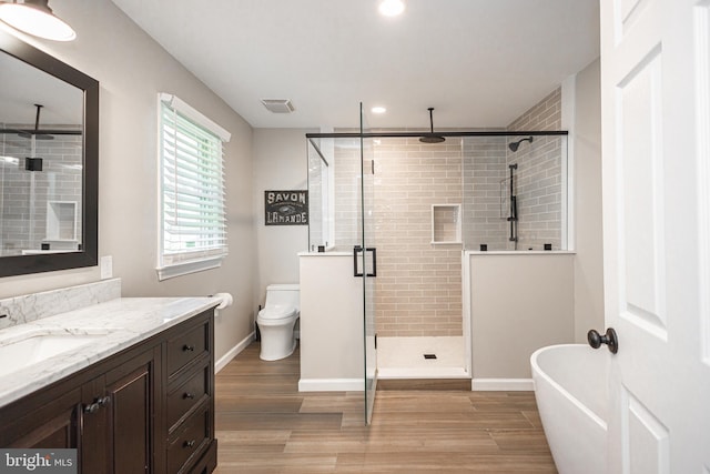 full bathroom featuring hardwood / wood-style floors, vanity, toilet, and plus walk in shower