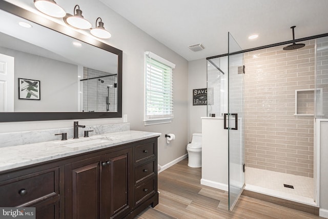 bathroom with vanity, toilet, an enclosed shower, and wood-type flooring