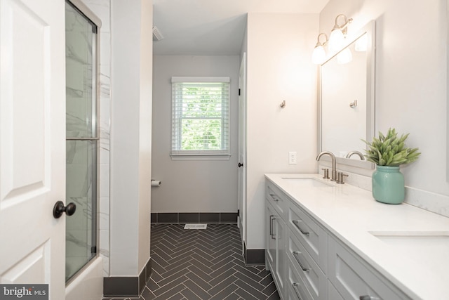 bathroom featuring tile patterned floors, vanity, and combined bath / shower with glass door