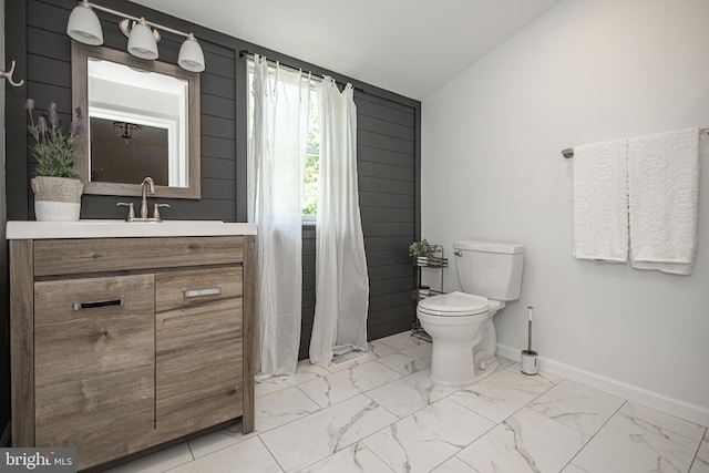 bathroom with vanity, toilet, and lofted ceiling