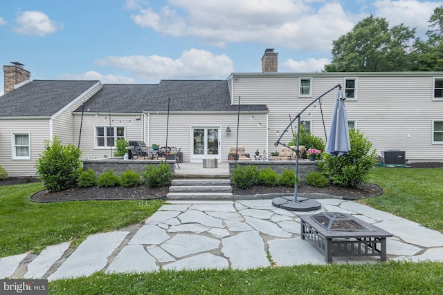 rear view of house featuring a yard, an outdoor fire pit, a patio, and central AC