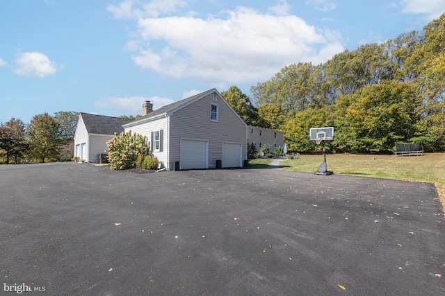 view of property exterior with a garage and a trampoline