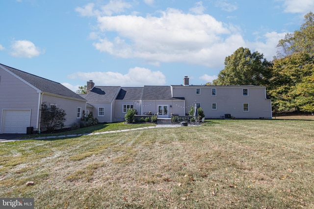 back of property with a lawn and french doors