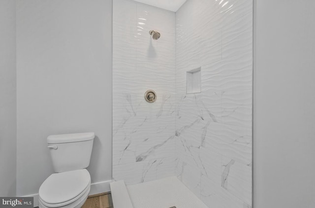 bathroom featuring toilet and tiled shower