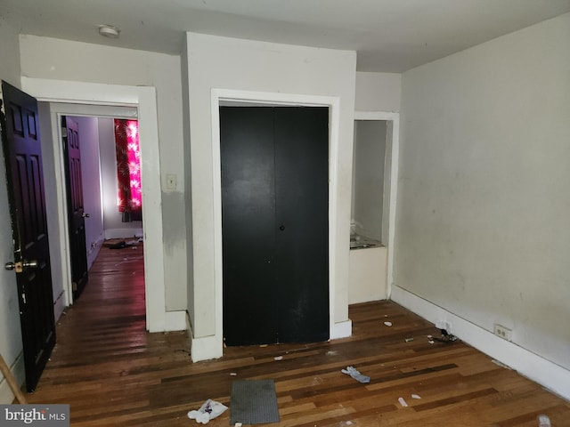 unfurnished bedroom with a closet and dark hardwood / wood-style floors