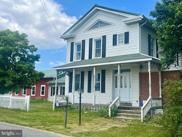 view of front of home with a front yard and covered porch