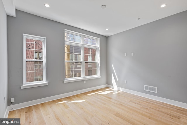 empty room featuring recessed lighting, light wood-type flooring, visible vents, and baseboards