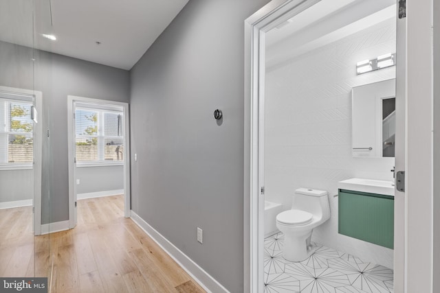 bathroom featuring baseboards, vanity, toilet, and wood finished floors