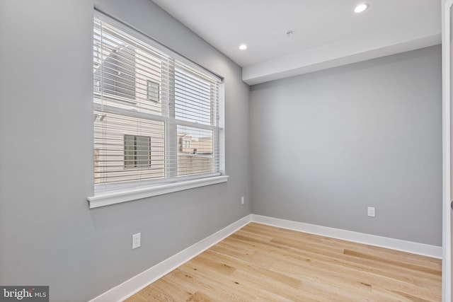 empty room with baseboards, wood finished floors, and recessed lighting